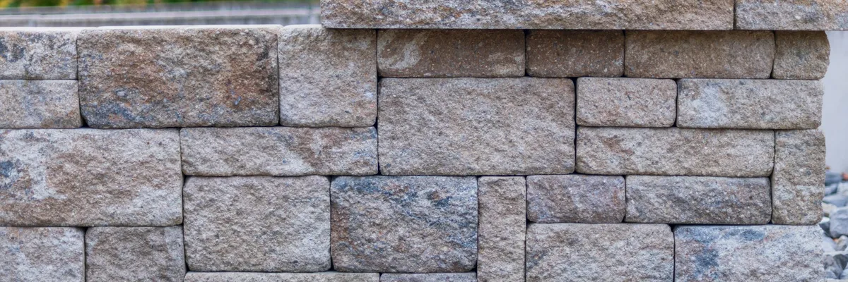 Garden retaining wall built from split-face blocks with cap stones