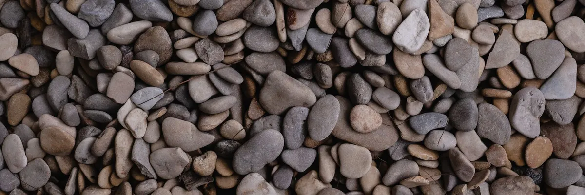 Smooth gray and brown river rock used as landscape ground cover