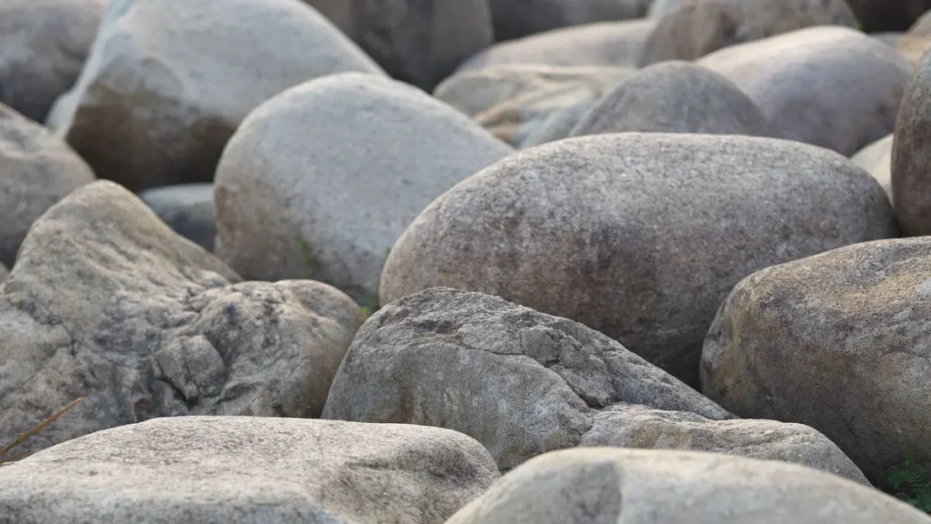 A layer of smooth river rock spread across a landscape bed